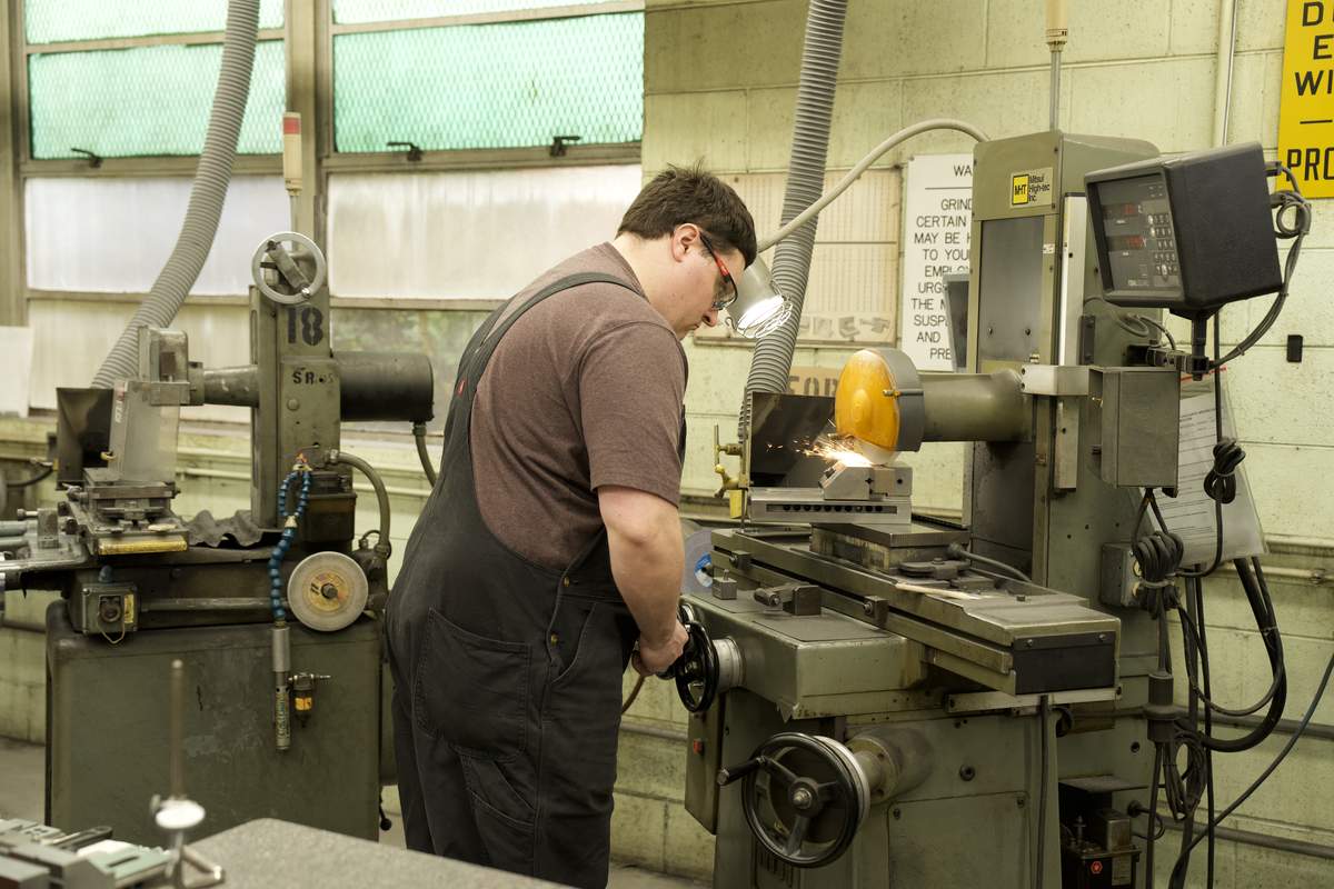 Manor Tool machinist grinding aerospace metal component — precision finishing for extreme environment performance