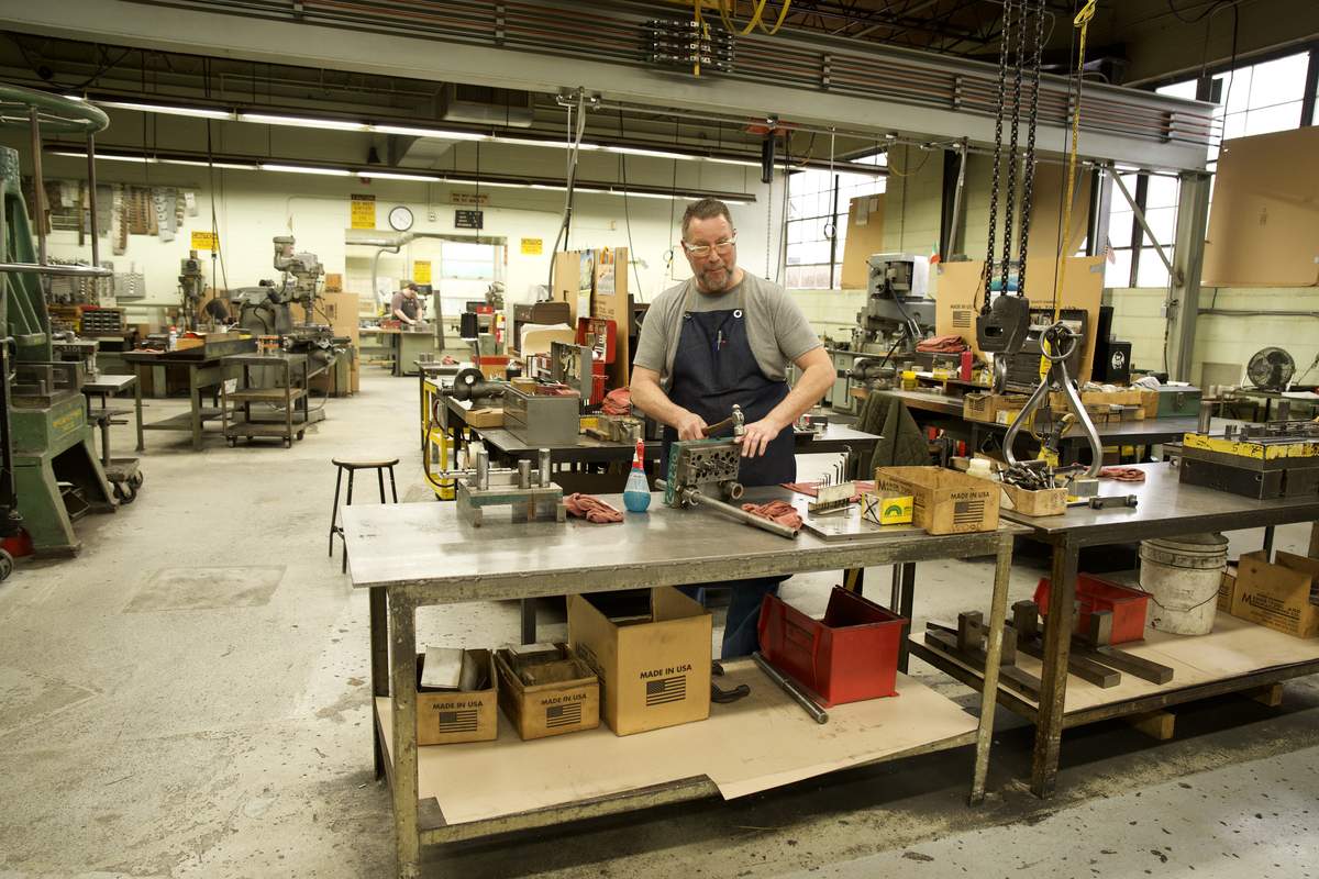 Manor Tool die maker at workbench — precision tool and die craftsmanship for aerospace manufacturing